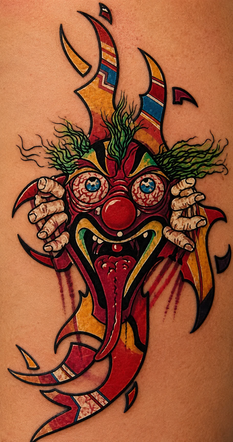 Color illustrative clown tattoo by Kevin Mokuahi — wild-eyed clown grasping a flaming ribbon, red and yellow palette