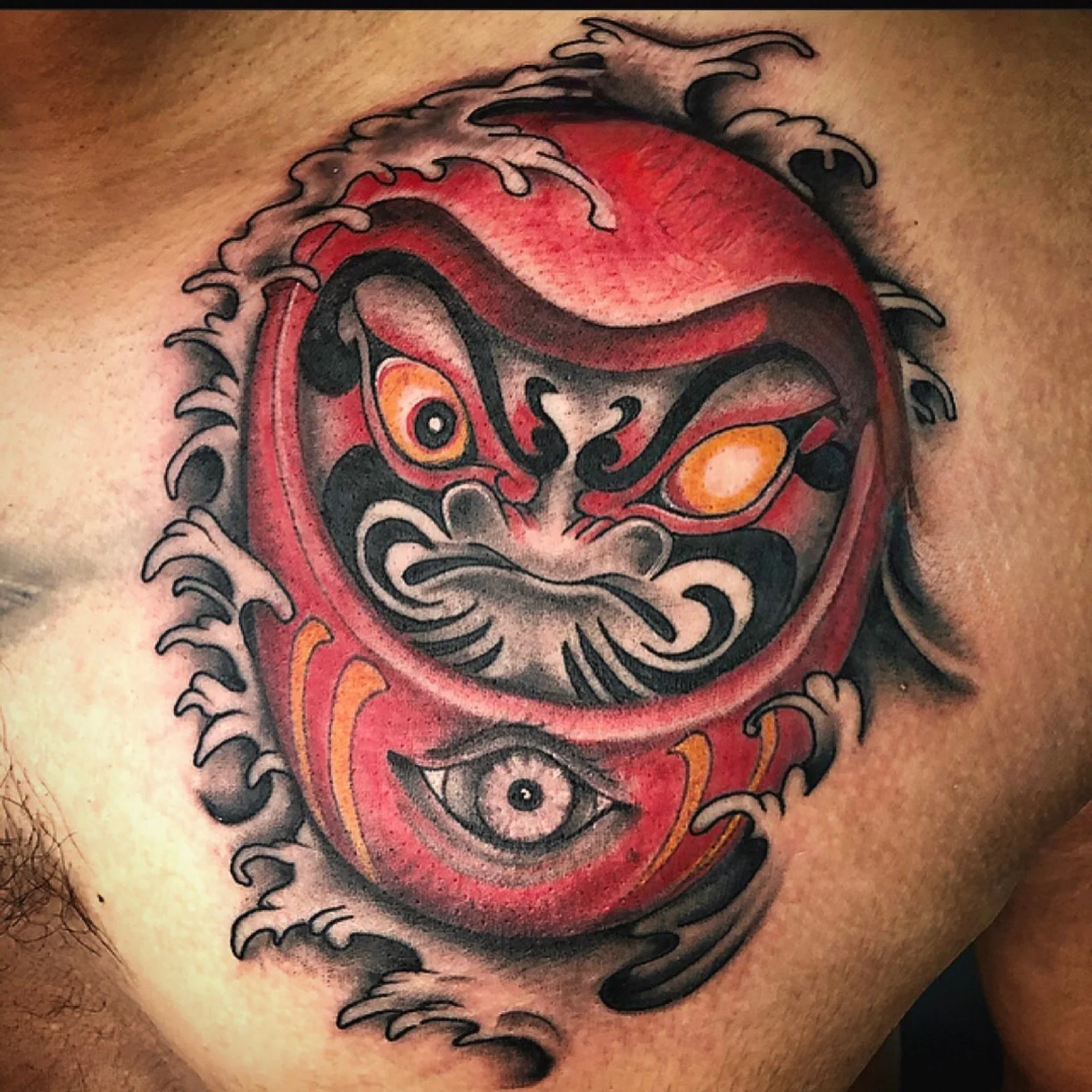 Red Daruma chest tattoo by Kevin Mokuahi